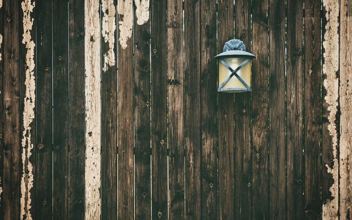 Vertical timber board fence with weathered dark stain