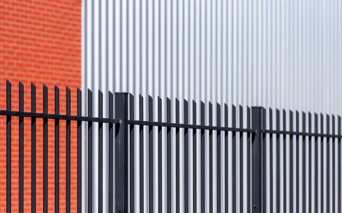 Black steel security railings alongside an industrial building
